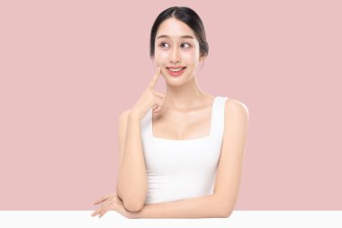 Genç Asyalı güzel bir kadının yakın plan portresi. Makyaj stili, sağlıklı ve mükemmel bir cilt. Pembe arka planda izole edilmiş cilt..