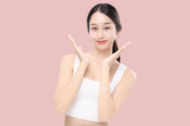 Genç Asyalı güzel bir kadının yakın plan portresi. Makyaj stili, sağlıklı ve mükemmel bir cilt. Pembe arka planda izole edilmiş cilt..