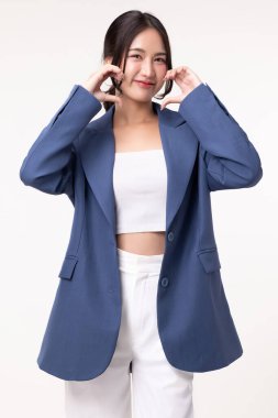 Güzel Asyalı genç iş kadını izole edilmiş beyaz arka planda kalp şeklinde el işareti yapıyor..