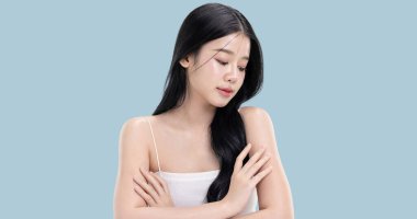 Parlayan ten, mavi arka planda izole edilmiş güzel, genç Asya modelinin makyaj stili..