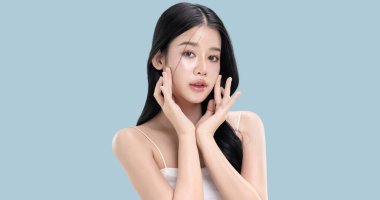 Parlayan ten, mavi arka planda izole edilmiş güzel, genç Asya modelinin makyaj stili..