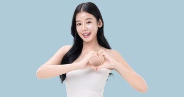 Parlayan ten, mavi arka planda izole edilmiş güzel, genç Asya modelinin makyaj stili..