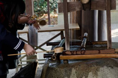 Geleneksel bir temizleme çeşmesinde yaşayanlar. Shimogamo Tapınağı. Shimogamo. Kyoto. Japonya.