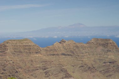 Cliffs in the Special Natural Reserve of Guigui and island of Tenerife in the background. Gran Canaria. Canary Islands. Spain. clipart