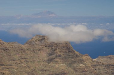 Cliffs in the Special Natural Reserve of Guigui and island of Tenerife in the background. Gran Canaria. Canary Islands. Spain. clipart