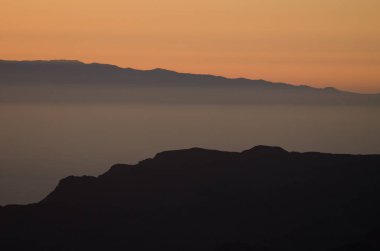 Gün batımında Gran Canaria 'dan Tenerife adasının doğusundaki siluet. Kanarya Adaları. İspanya.