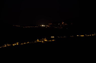 Village of El Toscon in the foreground and town of Artenara in the background at night. Gran Canaria. Canary Islands. Spain. clipart