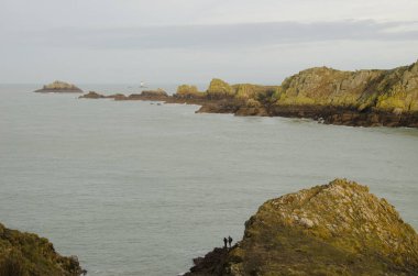 Balıkçılar, kayalık burunlar ve deniz feneri. Pointe du Grouin. Brittany. Fransa.