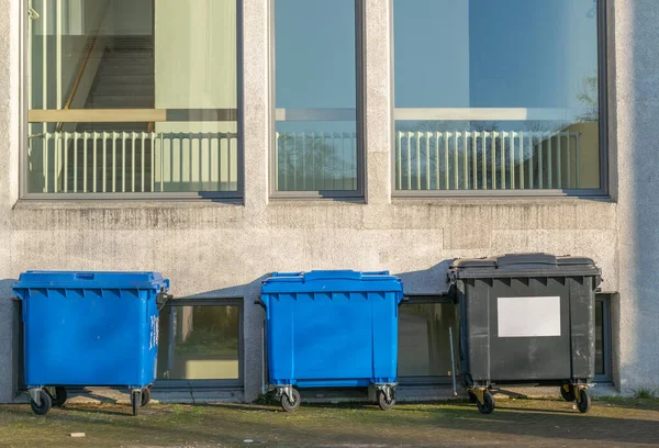 A row of garbage containers for recycling to separate waste, residual waste, paper and plasitc