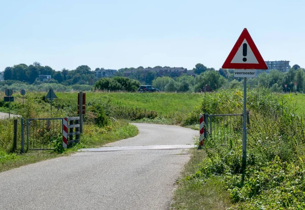 stock image Dutch traffic sign of 'watch out a Cattle grid' in front of a Cattle grid and dutch dyke in an european polder landscape