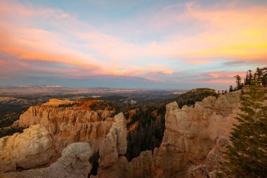 Utah 'taki Bryce Canyon Ulusal Parkı, günbatımında eşsiz kaya oluşumları ve renkli gökyüzüne karşı geniş manzaralarla çarpıcı bir manzara sunar. Maceracılar ve doğa severler için nefes kesici bir manzara.