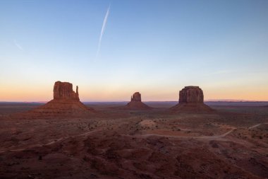 Arizona 'daki Navajo Anıt Vadisi Kabile Parkı' nda gün doğumu muhteşem kum taşı oluşumlarını gözler önüne seriyor. Çöl manzarasının doğal güzelliğini gözler önüne seren ikonik ve güzel bir manzara.