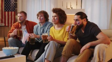 Amerikan futbol taraftarları TV 'de maç izleyip bira içiyorlar, ABD takımı için tezahürat yapıyorlar. Avrupa ve Dünya Futbol Kupası, Almanya, ABD, Kanada, Meksika. Spor ve futbol hayranları. Yavaş Hareket