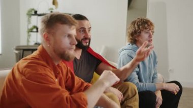 Erkek İspanyol taraftarlar TV 'de maç izleyip abur cubur yiyorlar, İspanya takımına tezahürat yapıyorlar. Avrupa Spor Futbol Kupası ABD, Kanada, Meksika. Futbol, spor ve futbol fanatikleri. Yavaş Hareket