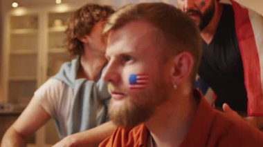 Amerikan futbol taraftarları TV 'de futbol maçı izliyor, ABD takımı için tezahürat yapıyorlar. Avrupa spor futbolu. Futbol kupası 2026 ABD, Kanada, Meksika. Spor ve futbol hayranları. Yavaş Hareket