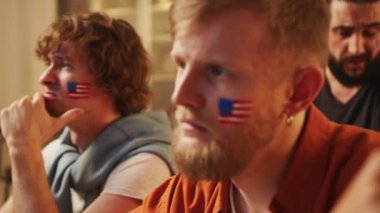 Amerikan futbol fanatikleri TV 'de maç izleyip bira içiyorlar, ABD takımı için tezahürat yapıyorlar. Avrupa Almanya ve Dünya Futbol Kupası 2026 ABD, Kanada, Meksika. Spor ve futbol hayranları. Yavaş Hareket