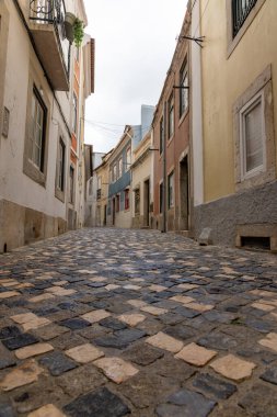 Çekici görüntüde, Lisbons Eski Kasabası 'nda renkli tarihi binaların sergilendiği bir kaldırım taşı ara sokağı yer alıyor. Portekiz 'in başkentini, kültürel cazibesini ve mirasını ele geçiriyor.