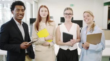 Çeşitli genç profesyonellerden oluşan bir grup, bir iş toplantısı sırasında modern bir ofis ortamında işbirliği yapıyor. Çeşitli şirket çalışanları dinamik ve yenilikçi bir ortamda birlikte çalışırlar.