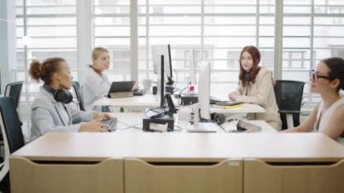 Çeşitli genç profesyonellerin bulunduğu ofis atmosferi işbirliği içinde bir iş toplantısı ve takım çalışması içerisindeydi. Başarılı bir şirket ortamı birlikte çalışma ve üretkenlik gösteriyor.
