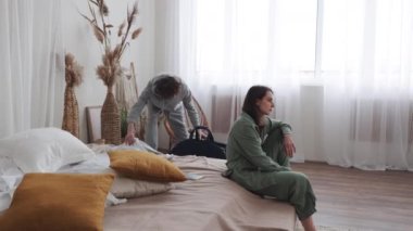 Rahat bir odada bavullu bir çift, ayrılmadan önce gerginlik gösteriyorlar. Duygusal yolculuklar için mükemmel..