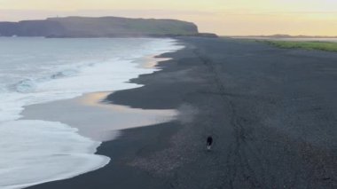 Sersemletici hava görüntülerinde İzlanda engebeli kıyı şeritleri, kara kumlu plajlar, dalgalı dalgalar ve alacakaranlıkta engin manzaralar sergilenmekte, bu uzak ve el değmemiş vahşi doğanın huzur dolu güzelliğini yansıtmaktadır.