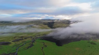 Sabahın erken saatlerindeki sis, İzlanda 'nın dolambaçlı nehrini ve yemyeşil tepelerini bu nefes kesici hava fotoğrafında güzel bir şekilde yakalamış. İzlanda. 