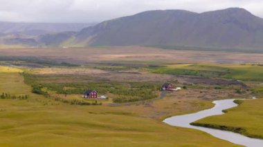 Çekici evler, yemyeşil çayırlar, dolambaçlı bir nehir ve görkemli dağların yer aldığı İzlanda 'nın nefes kesici hava manzaralarını keşfedin. Doğa meraklıları için mükemmel..