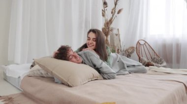 Genç çift, güzel bir odada, rahat bir yatakta sarılıp, rahatlıyor. Birlikte huzurlu anların tadını çıkarıyorlar. Ağır çekim, 4k