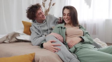 Sıcak bir odada genç bir çift, yatakta huzurlu bir anı paylaşıyorlar, sıcaklığın ve samimiyetin tadını çıkarıyorlar. Ağır çekim, 4k