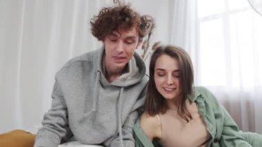 Samimi giyinmiş mutlu genç çift neşeli anları, kahkahaları ve gülümsemeleri paylaşıyor..