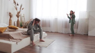 Konforlu yatak odalarında, ilişki sorunları olan, evde duygusal çatışma ve stresle karşı karşıya kalan bir çift.