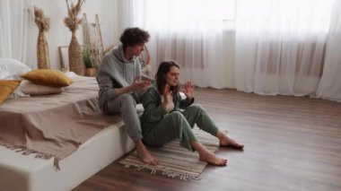 Modern, minimalist bir odada kaliteli vakit geçiren bir çift doğal ışıkla dolup huzurlu bir atmosfer yaratıyor.