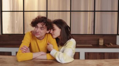 Bir çift ahşap bir masada oturuyor, yumuşak doğal ışıkla sevgi dolu ve samimi bir sohbete girişiyor..