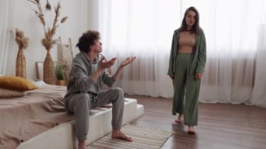 Bir çift, yatak odasında hararetli bir tartışma içinde, gerginlik ve duygusal gerginlik sergiliyor.