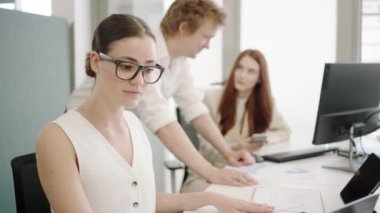 Profesyoneller, bir şirket ortamında bir proje üzerinde çalışan bir iş toplantısında işbirliği yaparlar. Çeşitli çalışanlar, yenilik ve takım çalışmasını teşvik etmek amacıyla modern bir ofis kurulumuna katkıda bulunuyor.