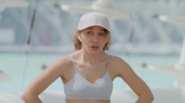 Kararlı genç bir bayan sporcu güneşli bir günde açık havada spor yapıyor, terlemeyi ve terlemeyi gösteriyor, spor ve güç eğitimine bağlılığını simgeliyor.