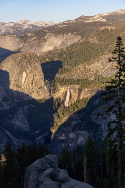 Yosemite Ulusal Parkları 'nı gün batımında, engebeli dağların ve sakin vadilerin üzerinde sıcak altın ışıkla nefes kesici bir güzellikle tecrübe edin. Görenleri büyüleyen çarpıcı bir manzara yaratın.