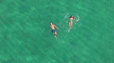 Bir hava çekimi, şafak vakti Oahus turkuvaz sularında süzülen iki yüzücüyü yakalar ve dünya çapında gezginleri ve doğa meraklılarını çeken nefes kesici güzelliği vurgular.