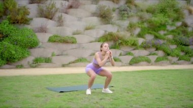 Formda ve güçlü bir kadın yoga minderinin üzerinde tutkuyla egzersiz yapıyor etkileyici atletik yeteneklerini ve sağlık gelişimine olan sarsılmaz bağlılığını sergiliyor.