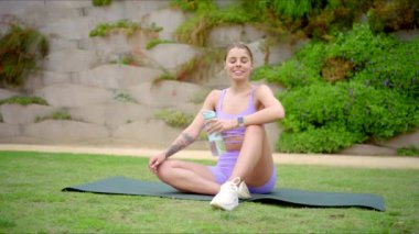 Güçlü ve güzel bir fitness kadını yoga minderinde zarifçe poz verir, atletizmini, zarafetini ve hayattaki sağlık, zindelik ve genel olarak sağlığına olan sarsılmaz bağlılığını ustalıkla gösterir.