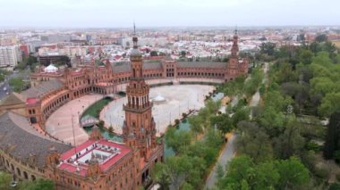 Canlı renkleri ve Seville 'in çarpıcı cazibesini yakalayan nefes kesici bir hava görüntüsü, çevresini saran yemyeşil çimlerin arasına kurulmuş tarihi mimarisini vurguluyor.