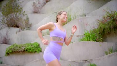 Formda, hevesli bir kadın modaya uygun atletizm kıyafetleriyle dışarıda egzersiz yapmaktan hoşlanır, koşarken sağlığını ve canlılığını gösterir ve yoga yaparken kendine güvenir, pozitif enerji yayar ve odaklanır.