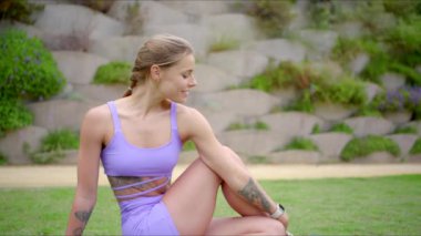 Güçlü ve son derece güzel bir fitness kadını yoga yapıyor, atletizmini ve zarif hareketlerini sergiliyor ve kendini adamış bir şekilde çeşitli egzersiz rutinini başarıyla uyguluyor.