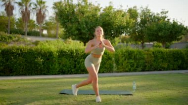 Neşeli bir ortamda, neşeli genç bir kadın enerjik bir şekilde spor yapar. Forma olan bağlılığını gösterir ve pozitif enerjisi ve sağlığına olan bağlılığıyla çevresindekilere ilham verir.