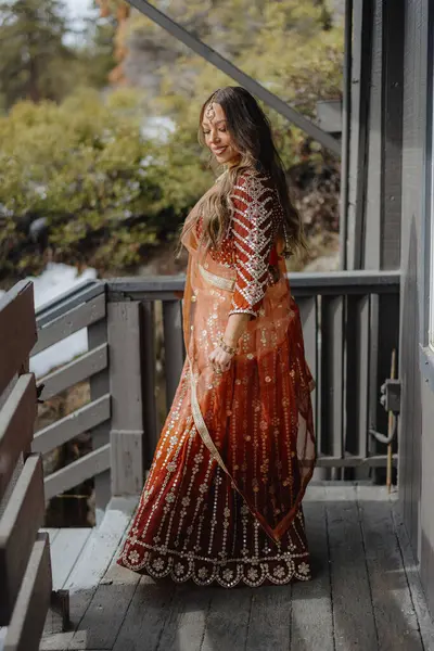 stock image A graceful woman elegantly poses in a truly stunning traditional Indian outfit, showcasing intricate and mesmerizing designs set against a beautiful natural backdrop that enhances her beauty