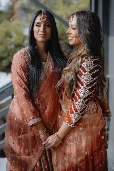 stock image Two women in stunning traditional outfits share a heartfelt moment, showcasing their deep love and cultural authenticity, making the experience truly special and memorable for all involved