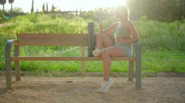 Çıkan genç kadın, çeşitli açık hava fitness aktivitelerine katılıyor, etkileyici atletizmini sergiliyor ve dingin, ferahlatıcı doğa güzelliği egzersizinden büyük keyif alıyor.