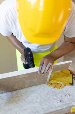 Parlak sarı bir miğfer ve yansıtıcı yelek giyen kendini adamış bir inşaat işçisi, ustalıkla karmaşık bir ev yenileme projesine girişiyor ve inşaat alanındaki olağanüstü uzmanlığını sergiliyor.