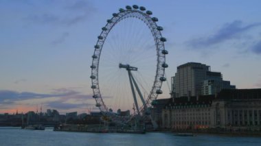 Londra 'nın ünlü London Eye ve tarihi Big Ben de dahil olmak üzere, Westminster, İngiltere' deki Thames nehrinin manzarası boyunca güzel bir şekilde yerleşmiş olağanüstü ve ikonik cazibesini keşfedin.