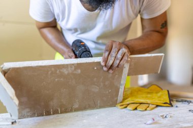 Kendini işine adamış bir inşaat işçisi, ev tadilatı sırasında malzemelere ustalıkla sondaj yapar, etkileyici yeteneklerini sergiler ve işçiliğin ve kaliteli maddenin bulunduğu pratik bir ortamda odaklanır.